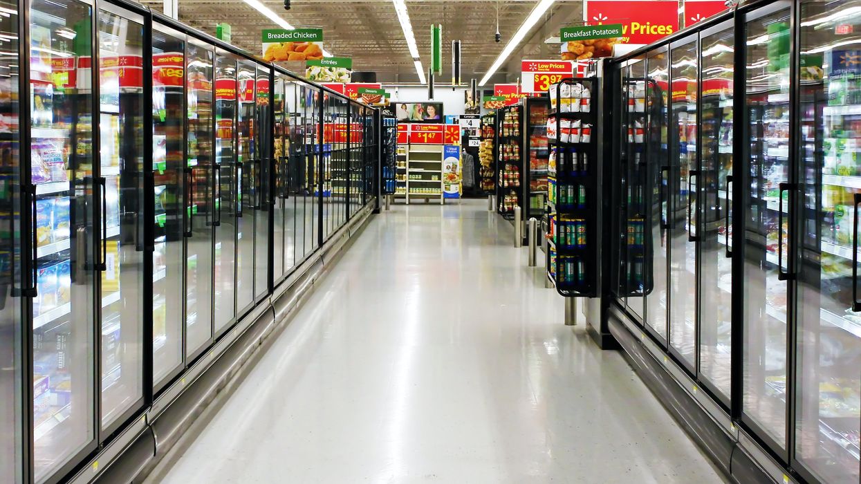 Allée des surgelés d'un Walmart avec des pancartes vertes et rouges.