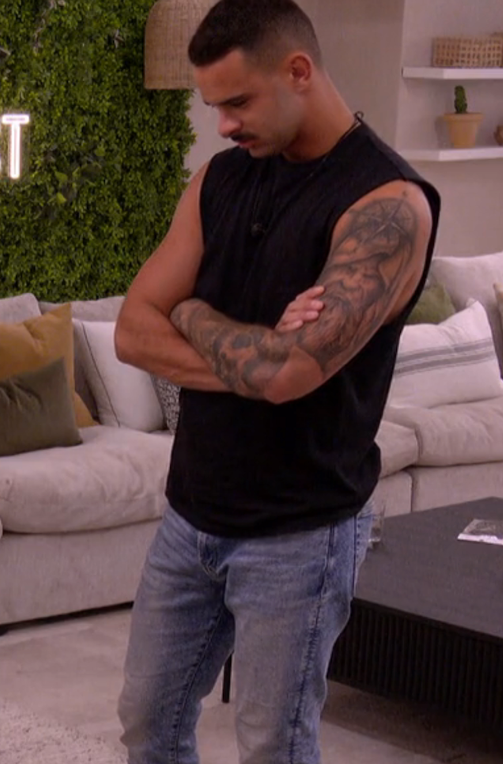 Anthony se tenant dans le salon dans la maison des gar\u00e7ons d'Occupation Double Andalousie.