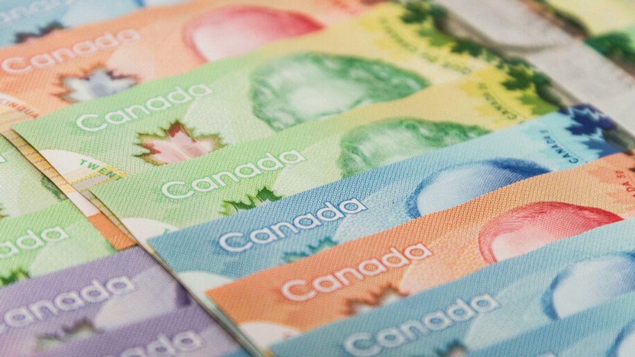Billets de banque canadiens alignés sur une surface plane.