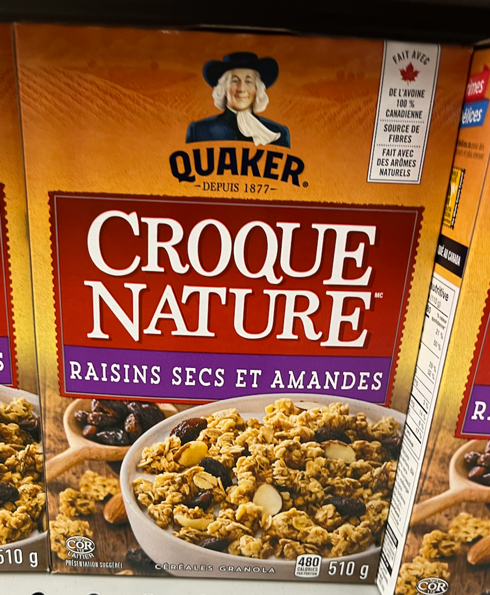 Bo\u00eete de c\u00e9r\u00e9ales granola Croque Nature de Quaker \u00e0 saveur de raisins secs et amandes sur une \u00e9tag\u00e8re d'\u00e9picerie.