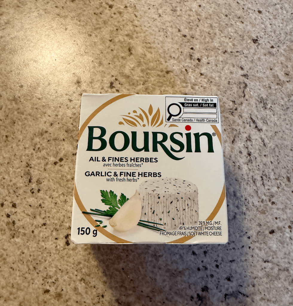 Bo\u00eete de fromage Boursin ail et fines herbes de 150 g achet\u00e9e au Liquidation Marie pos\u00e9e sur un comptoir de cuisine.