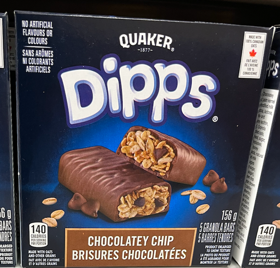 Bo\u00eetes de barres tendres Dipps de Quaker aux brisures chocolat\u00e9es sur une tablette d'\u00e9picerie.