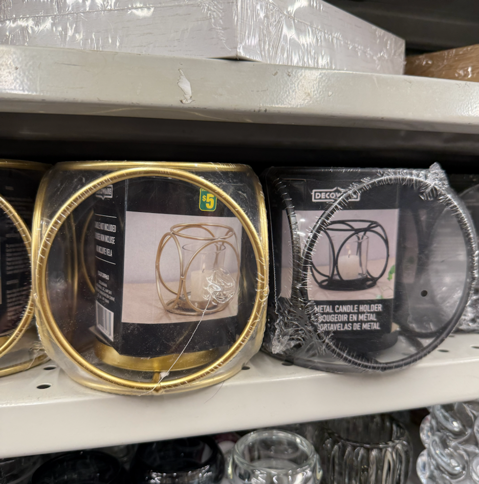 Bougeoirs en m\u00e9tal de forme arrondie, offerts en finition dor\u00e9e et noire, expos\u00e9s sur une tablette Dollarama.