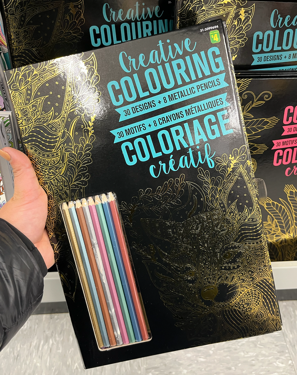 Cahier de coloriage pour adultes noir avec dessins dor\u00e9s m\u00e9talliques. Vendu avec huit crayons.