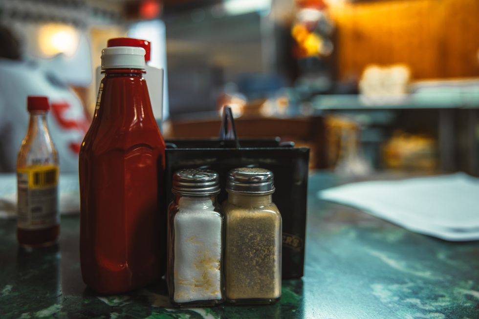 Condiments, sali\u00e8re et poivri\u00e8re sur une table.
