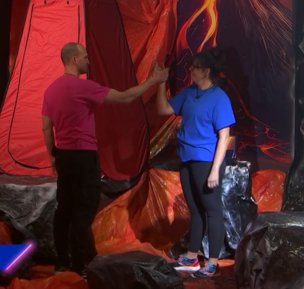 Daniel Savoie et Jo\u00eblle Par\u00e9-Beaulieu se tapent dans la main, complices, \u00e0 Big Brother C\u00e9l\u00e9brit\u00e9s.