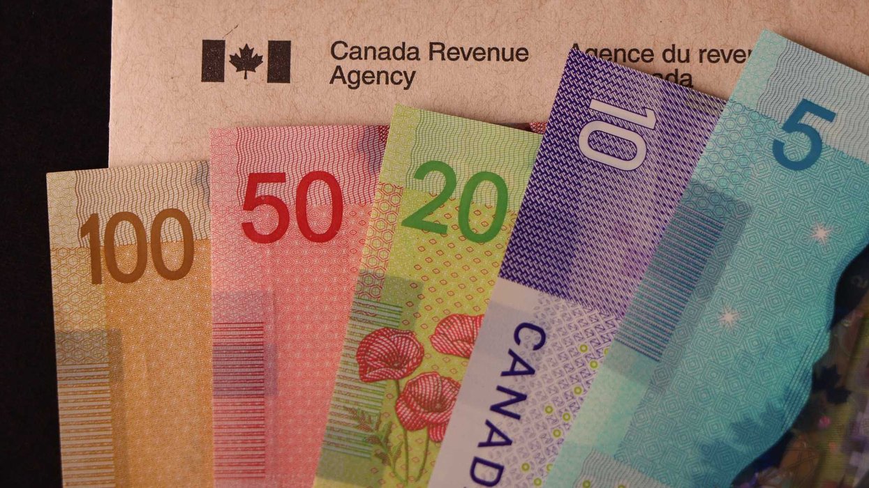 De l'argent canadien et une enveloppe de l'Agence du revenu du Canada.
