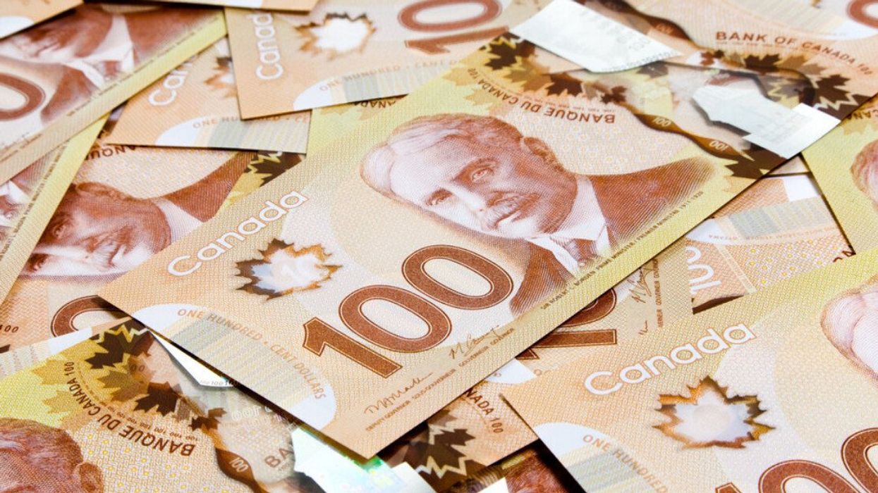 Des billets de 100 $ étalés sur une surface plane.