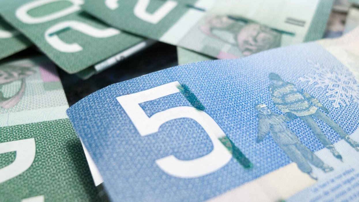 Des billets de 5 $ et 20 $ canadien photographiés de près.