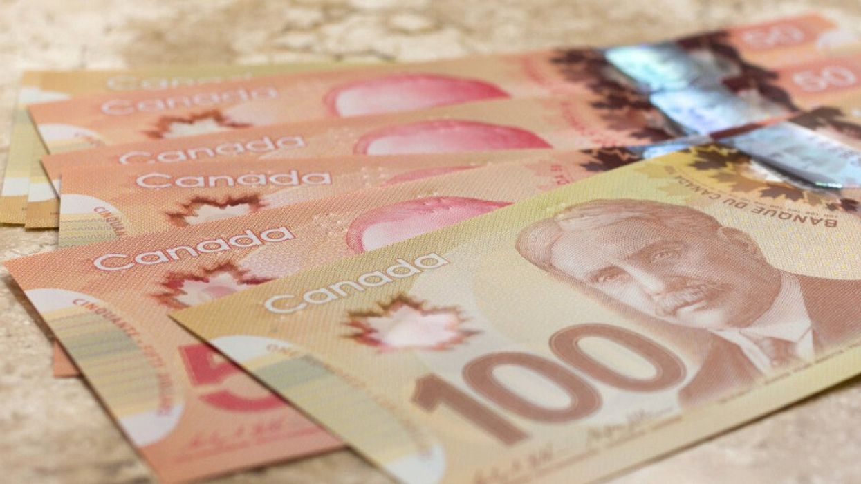 Des billets de 50 $ et 100 $ canadien étalés sur une table.