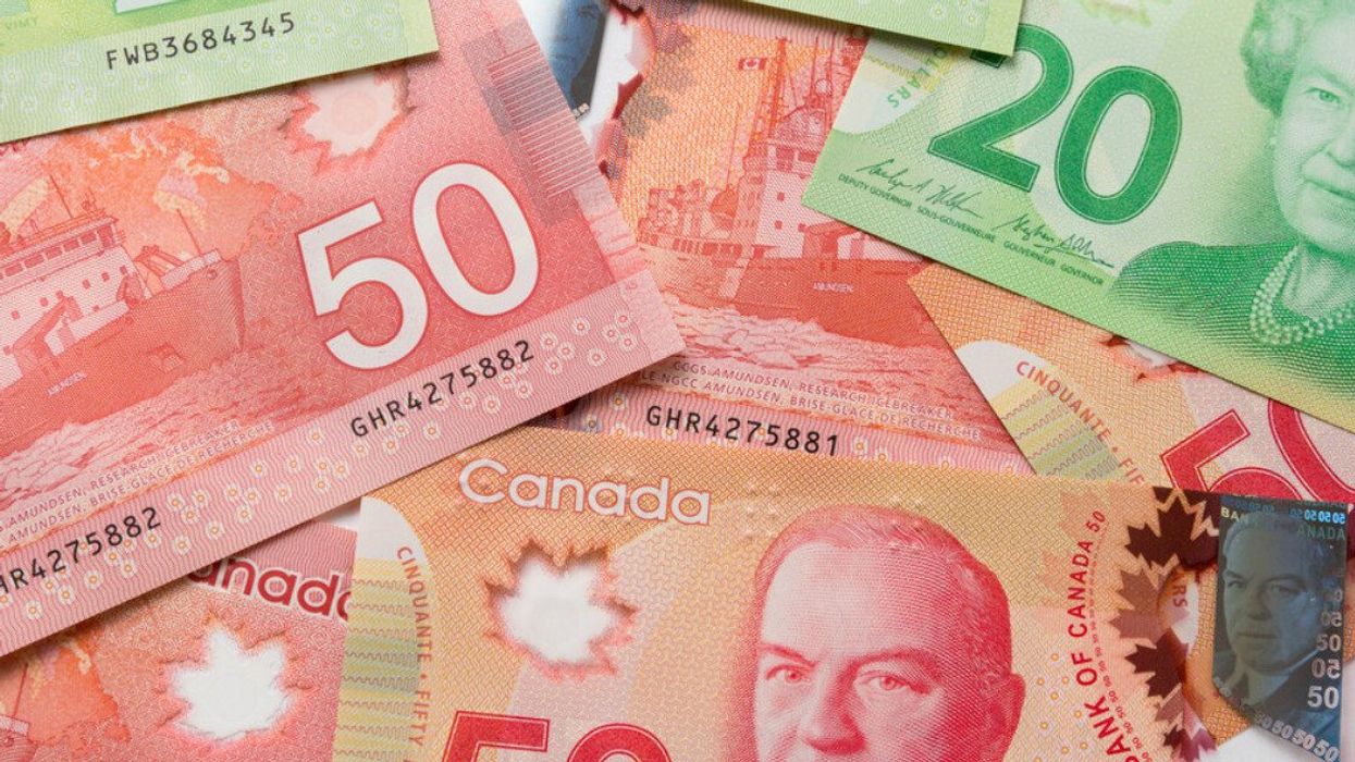 Des billets de 50 $ et 20 $ canadien étalés sur une surface plane.