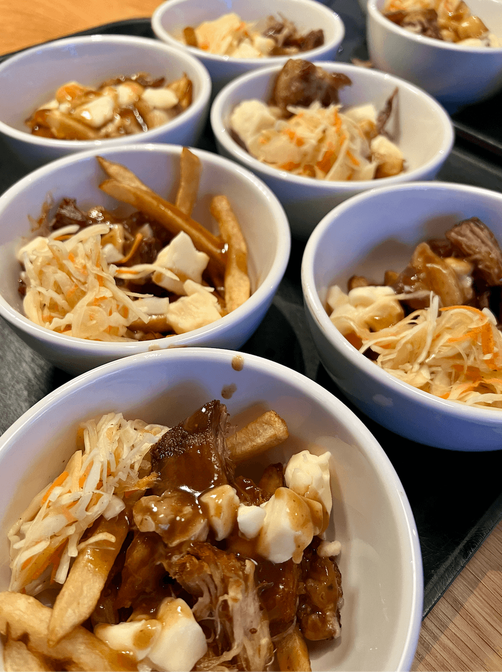 Des bols de poutine avec des morceaux de griot et du pikliz, une salade de chou ha\u00eftienne.