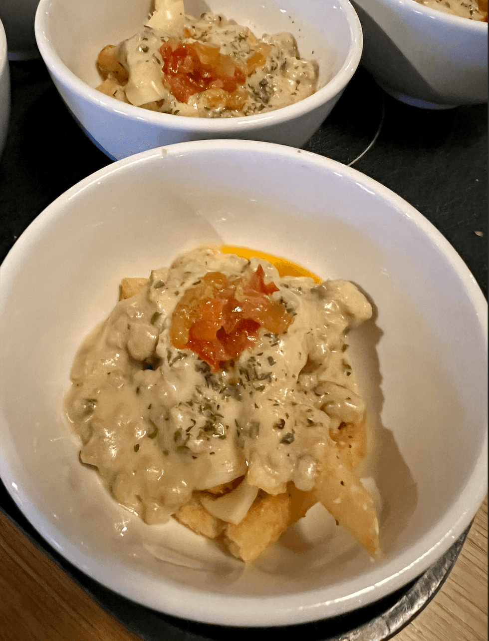 Des bols de poutine avec une sauce blanche et une relish de piments.