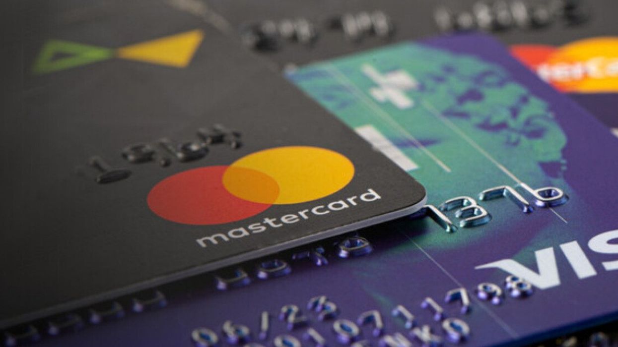 Des cartes de crédit Mastercard et Visa sont dispersées sur une surface plane.