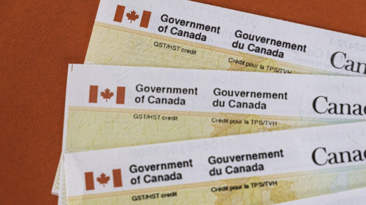 Des chèques du gouvernement du Canada sont placés en éventail sur une table.