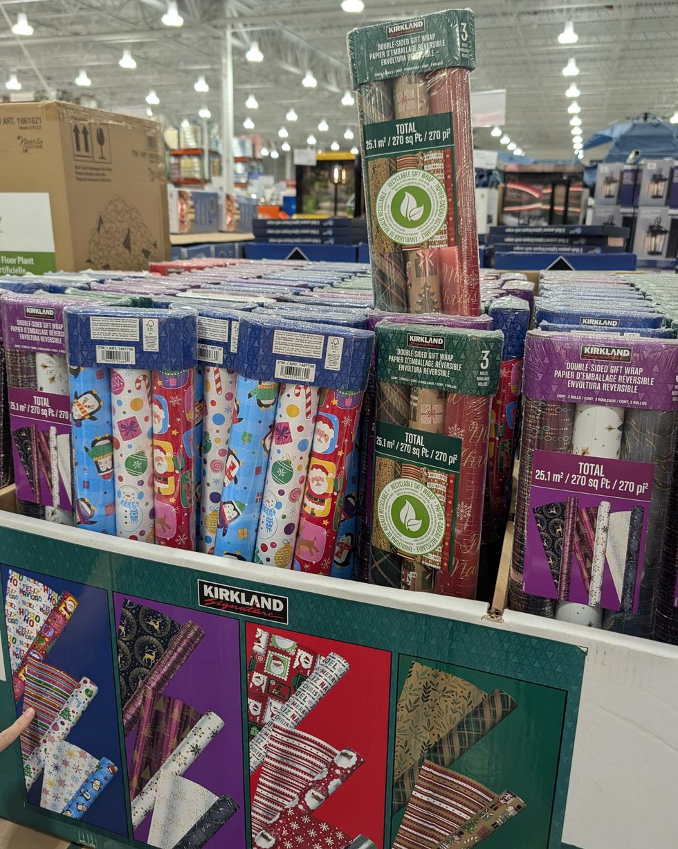 Des ensembles de rouleaux de papier d'emballage de No\u00ebl \u00e0 diff\u00e9rents motifs vendus dans le rayon des articles saisonniers chez Costco.