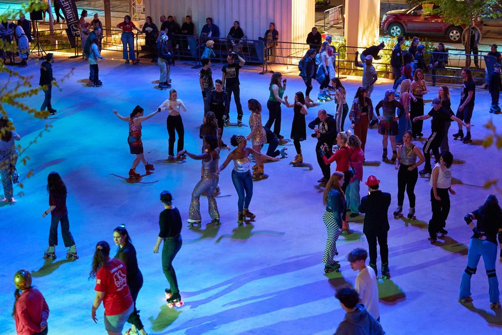 Des gens en patins \u00e0 roulettes \u00e0 la patinoire de l'esplanade Tranquille.