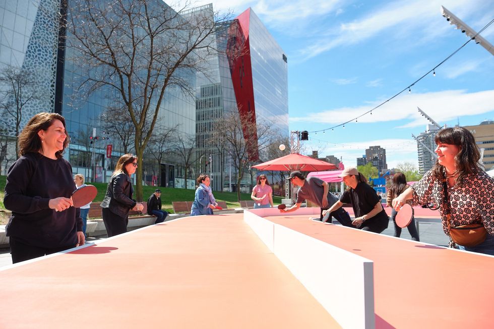 Des gens qui jouent sur des tables de ping ping ext\u00e9rieures \u00e0 Montr\u00e9al.