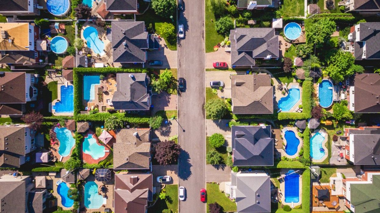 Des maisons avec leur cour et piscine dans un quartier résidentiel vu de haut.