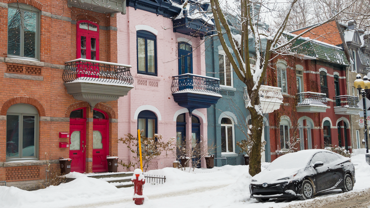 Des maisons colorées en rangée dans une rue enneigée à Montréal.