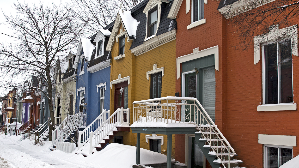 Des maisons colorées en rangée sur une rue enneigée à Montréal.