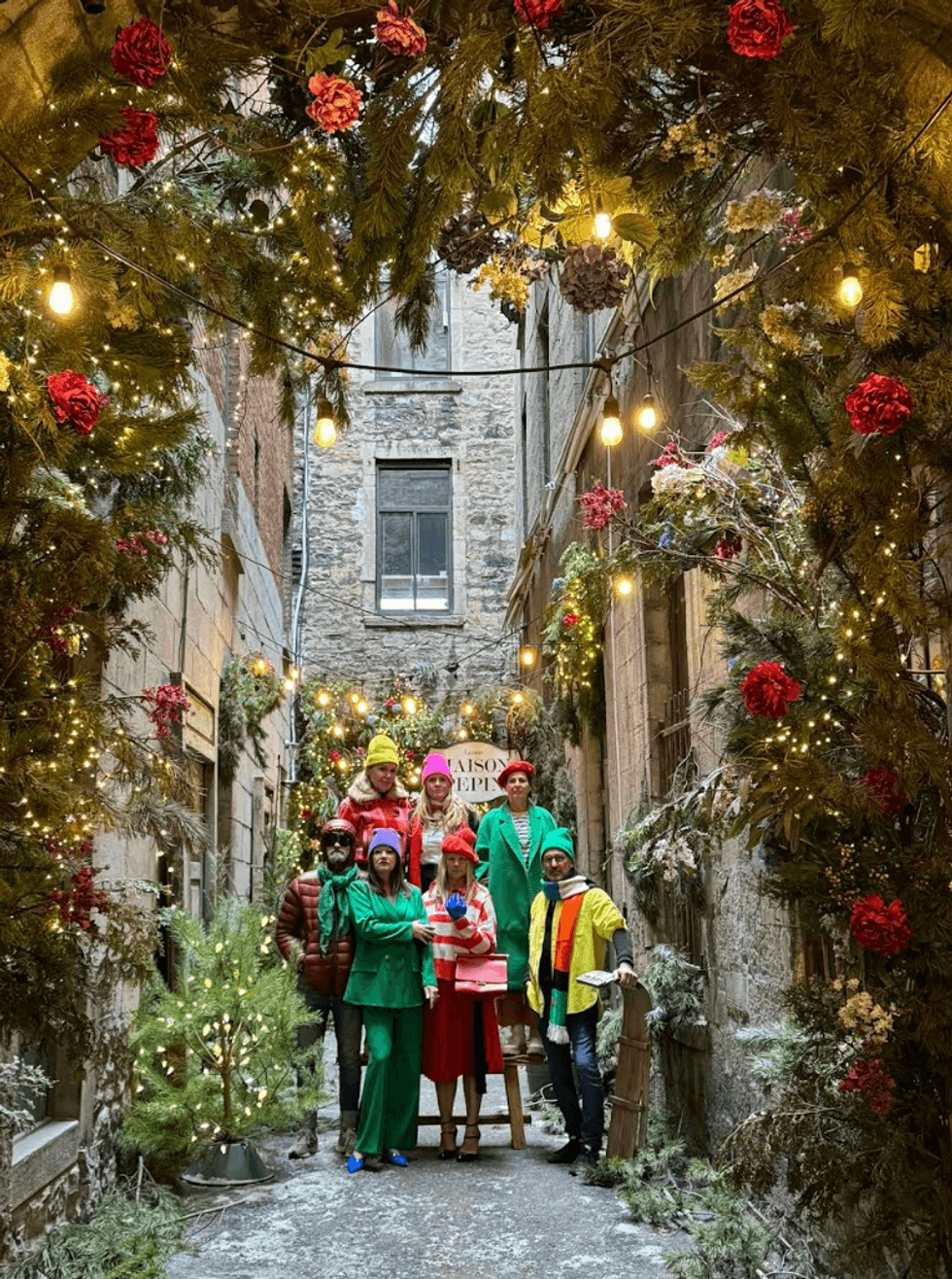 Des personnes aux habits color\u00e9s prennent la pose dans une ruelle de No\u00ebl.