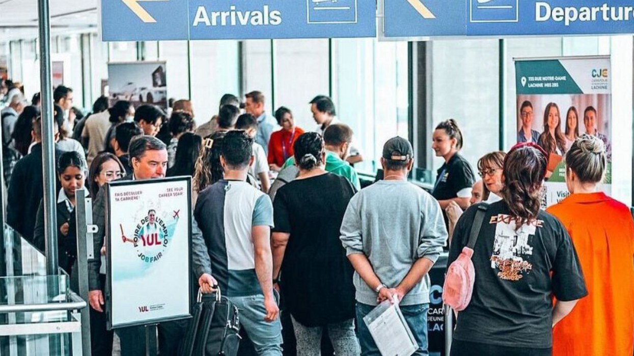 Des personnes font la file devant des kiosques d'une foire à l'emploi à l'aéroport de Montréal.