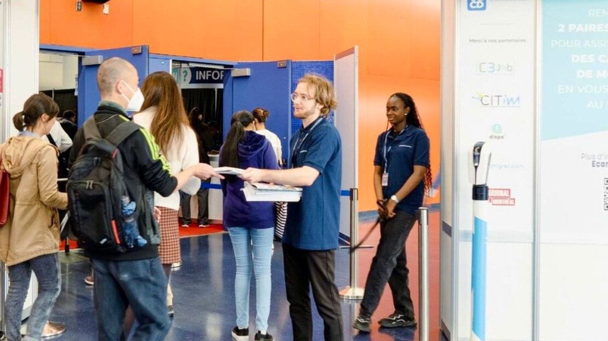 Des personnes font la file pour entrer dans un événement d'emploi.