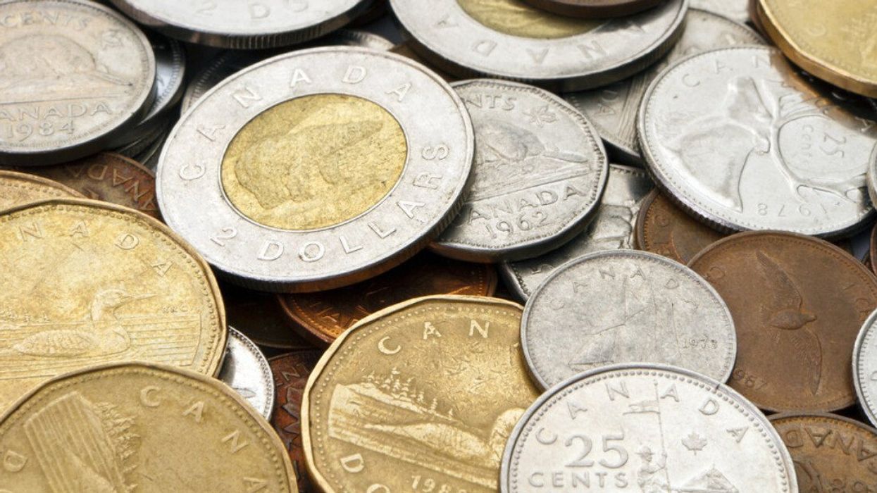 Des pièces de monnaie canadienne sont dispersées sur une surplace plate.