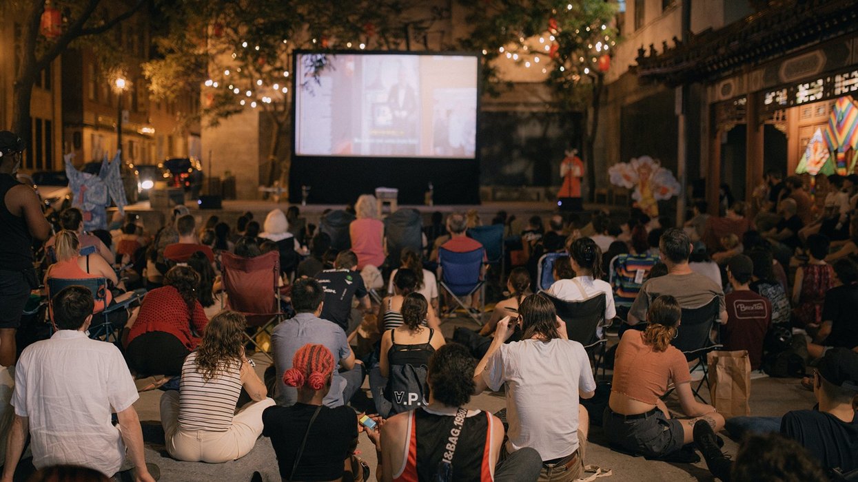 Des spectateurs et spectatrices devant la projection d'un film sous la belle étoile à Montréal.