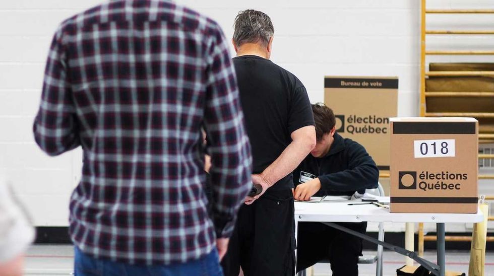 Des \u00e9lecteurs arrivent \u00e0 un lieu de vote pour voter.