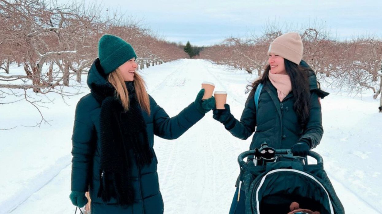 Deux femmes avec un café à la main se regardent.