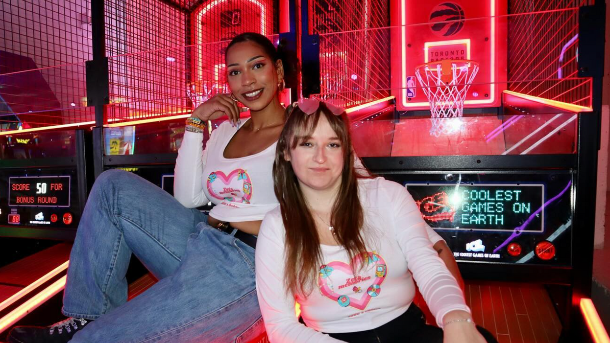 Deux personnes assises sur des jeux d'arcade de basketball.
