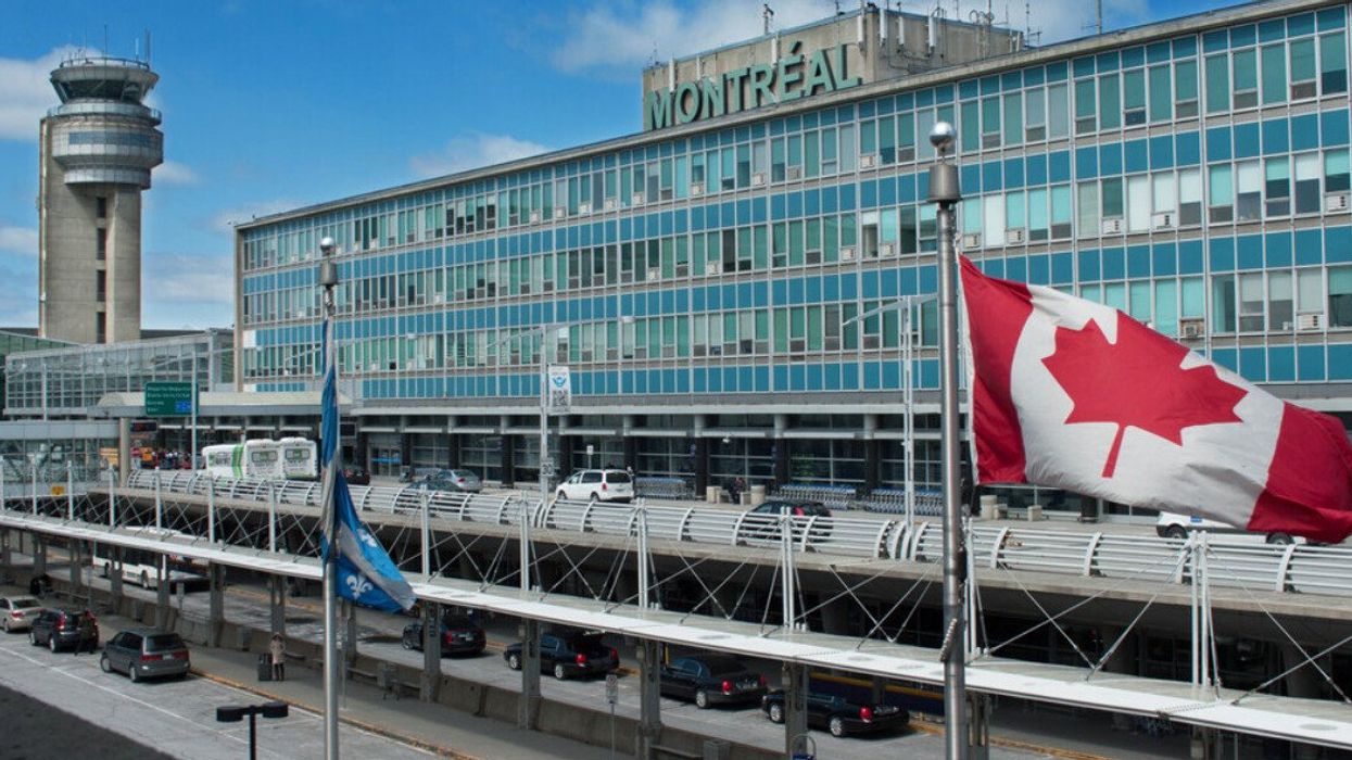 Devanture de l'Aéroport International Montréal-Trudeau avec un drapeau du Canada.