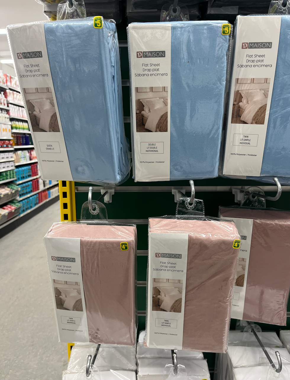 Draps plats pour le lit rose et bleu dans leur emballage au Dollarama.