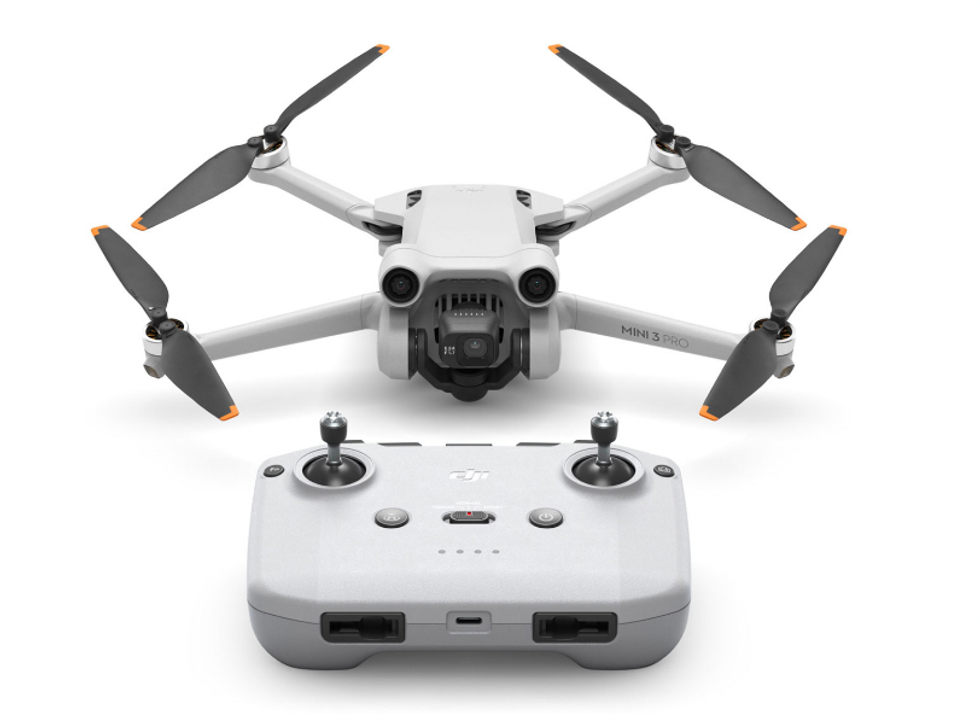 Drone quadricopt\u00e8re gris p\u00e2le avec sa t\u00e9l\u00e9commande.