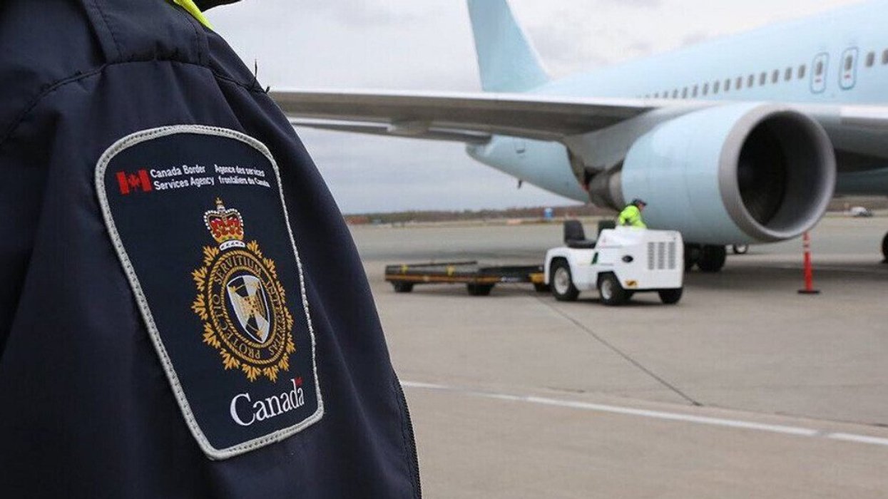 Employé de l'Agence des services frontaliers du Canada devant un avion.