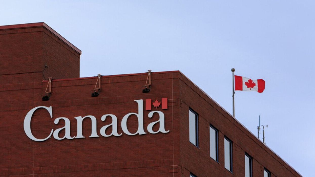 Enseigne du Gouvernement du Canada et un drapeau sur un édifice fédéral.