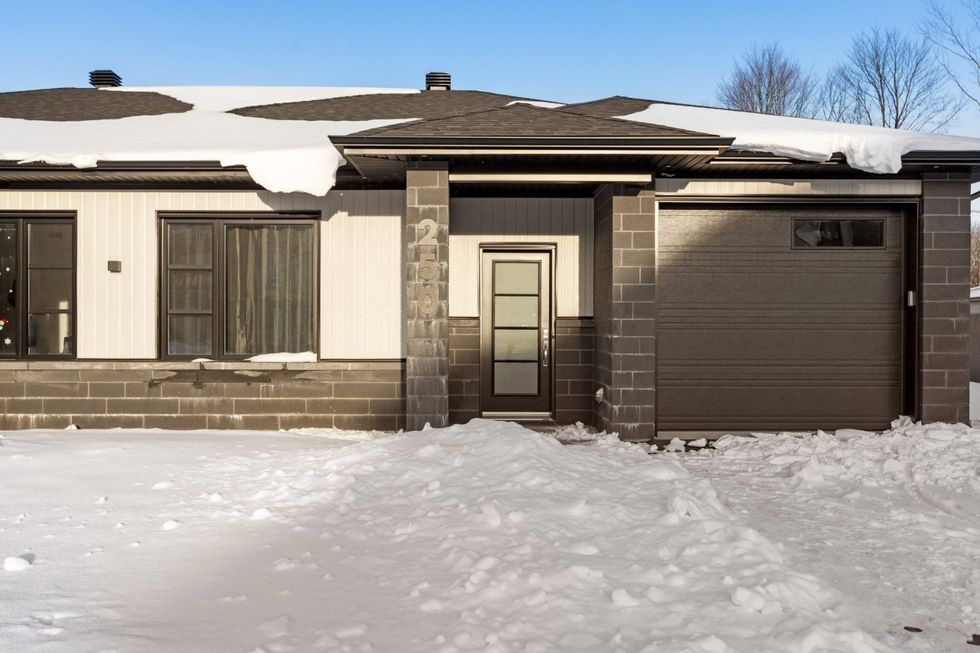 Fa\u00e7ade grise et blanche d'une maison \u00e0 vendre \u00e0 Trois-Rivi\u00e8res.