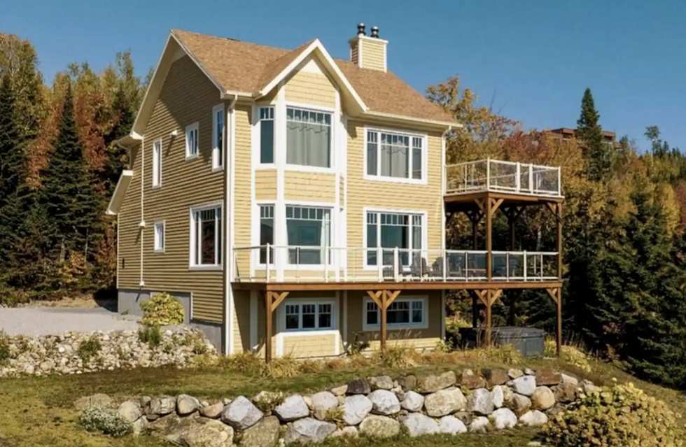 Face arri\u00e8re d'un chalet \u00e0 \u00e9tages jaune.