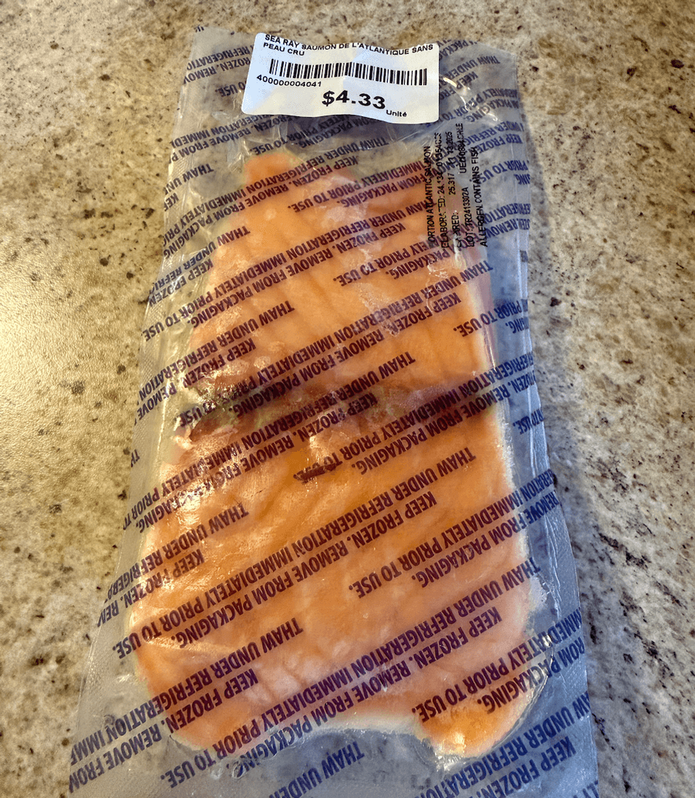 Filet de saumon de l'Atlantique sous vide surgel\u00e9 achet\u00e9 au Liquidation Marie pos\u00e9 sur un comptoir.