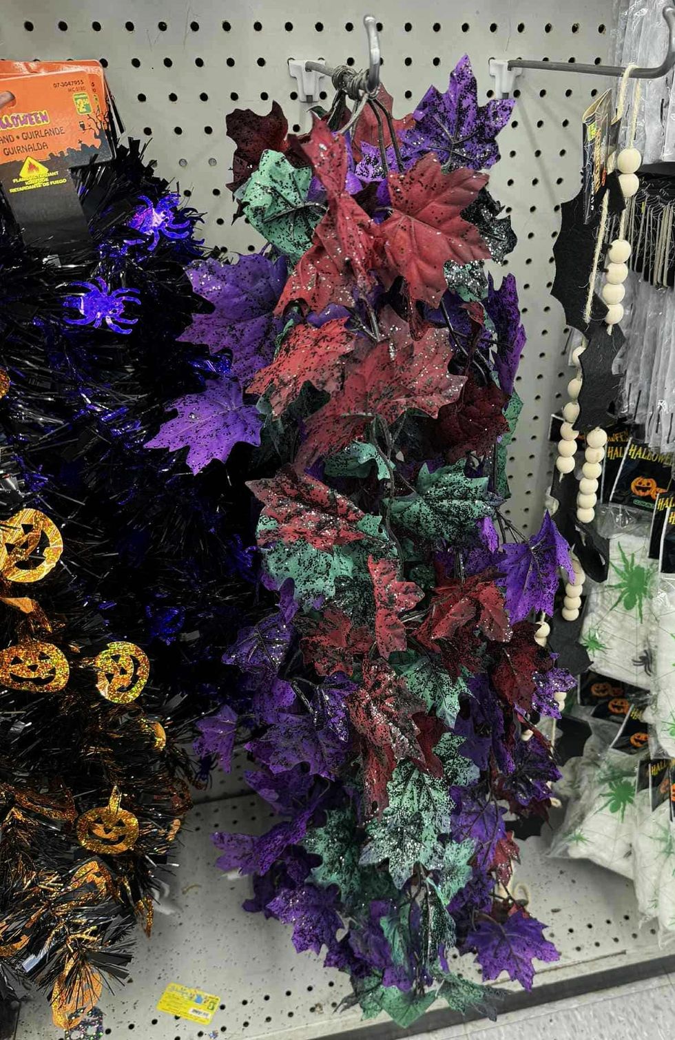 Guirlande de feuillage aux teintes rouge, vert, violet et noir.