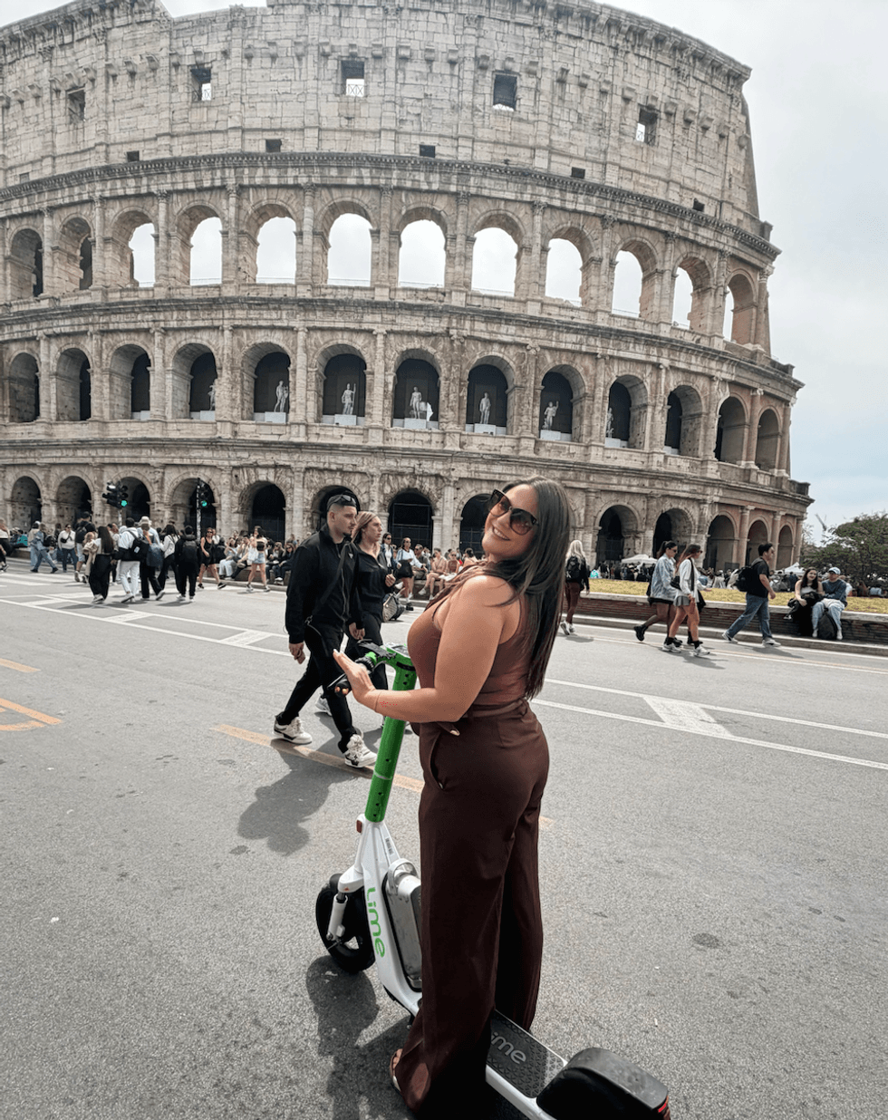 Izabelle Bee en trotinette devant le Colis\u00e9e de Rome.