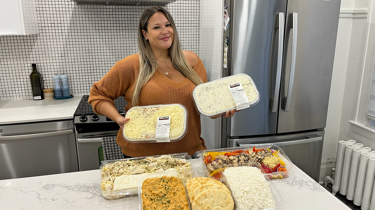 Izabelle Bee tient deux repas prêts-à-manger, et 3 sont sur le comptoir.