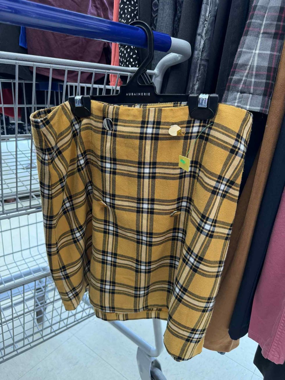 Jupe carreaut\u00e9e jaune, noire et blanche de style \u00e9coli\u00e8re dans la section liquidation pour adultes de la friperie Au Grenier Populaire.