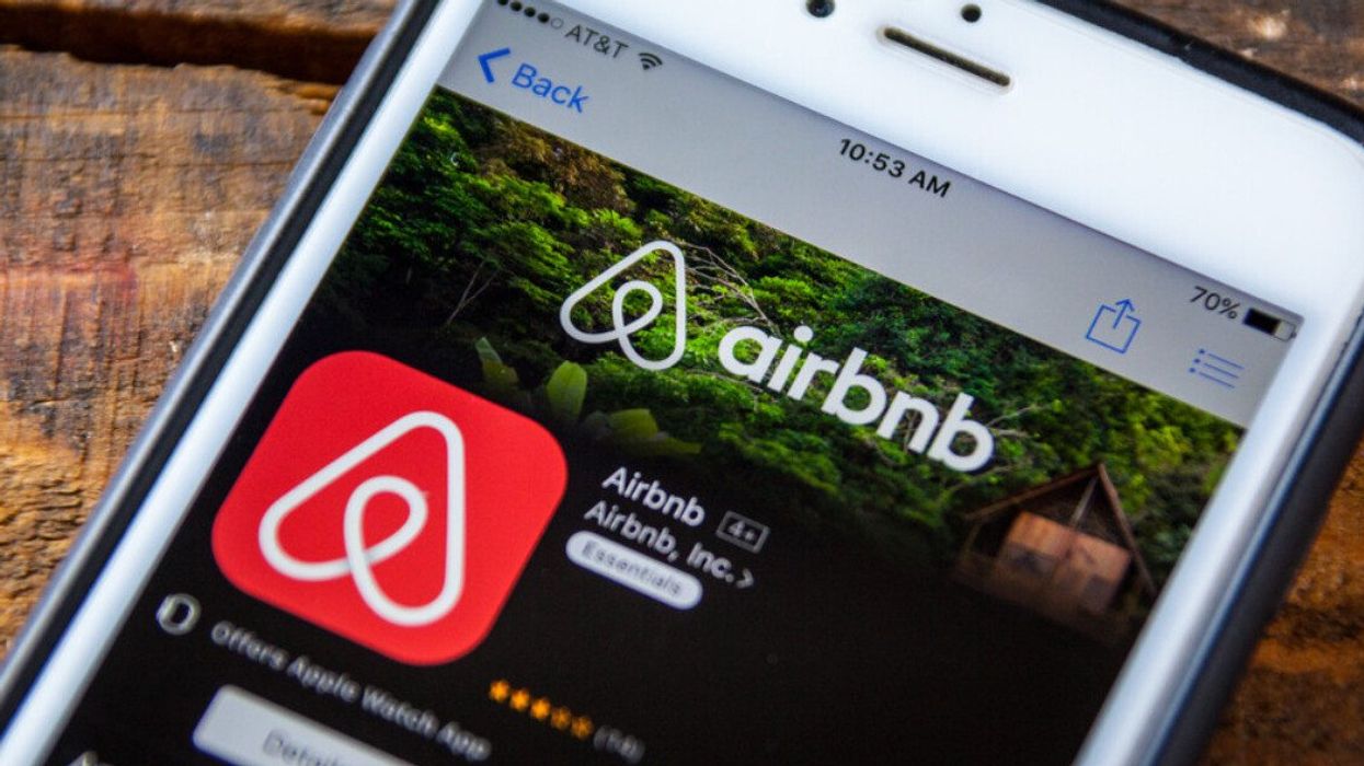 L'application Airbnb est ouverte sur un téléphone placé sur une table en bois.