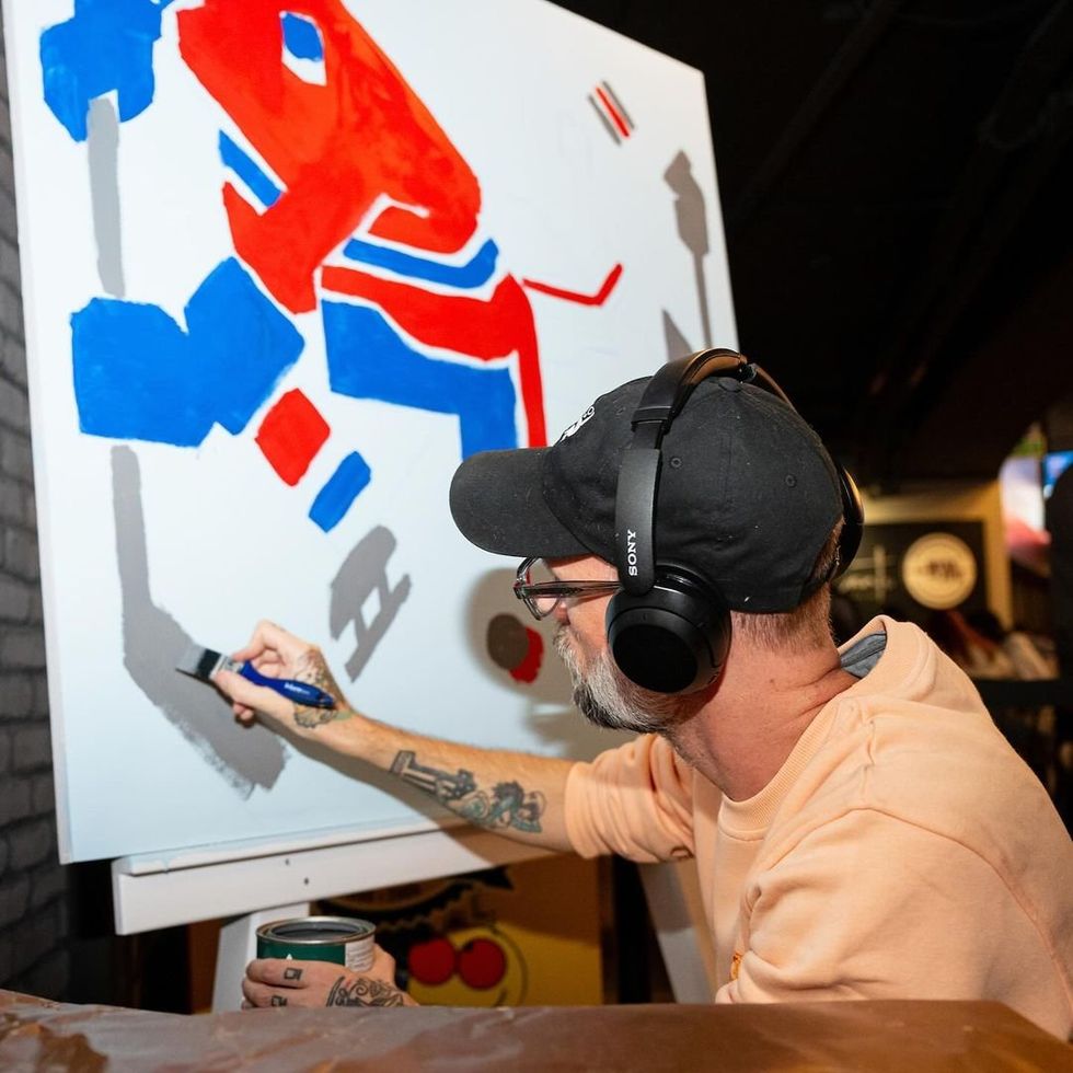 L\u2019artiste Meka en train de peindre sa toile.