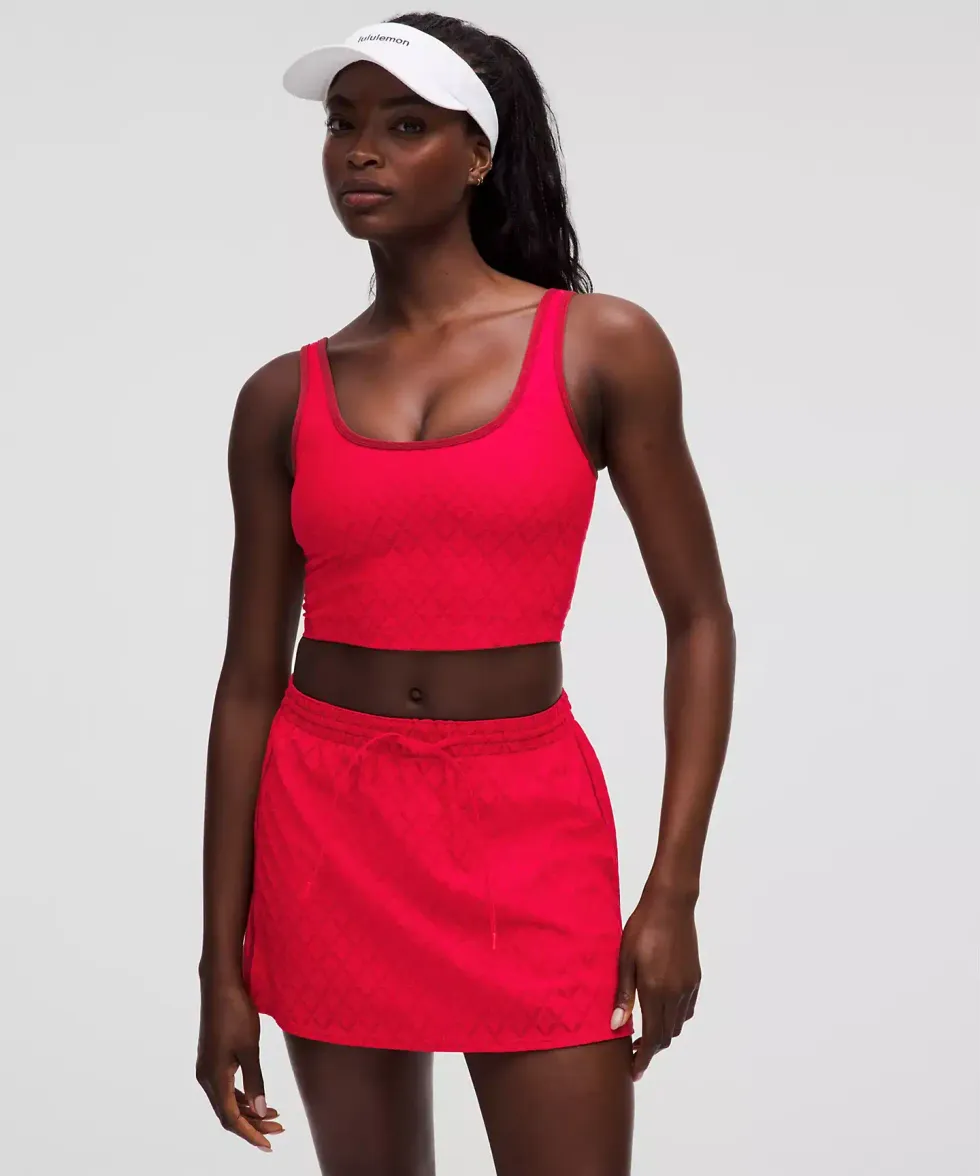 La camisole de tennis en maille textur\u00e9e rouge port\u00e9e par un mod\u00e8le sur le site de lululemon.