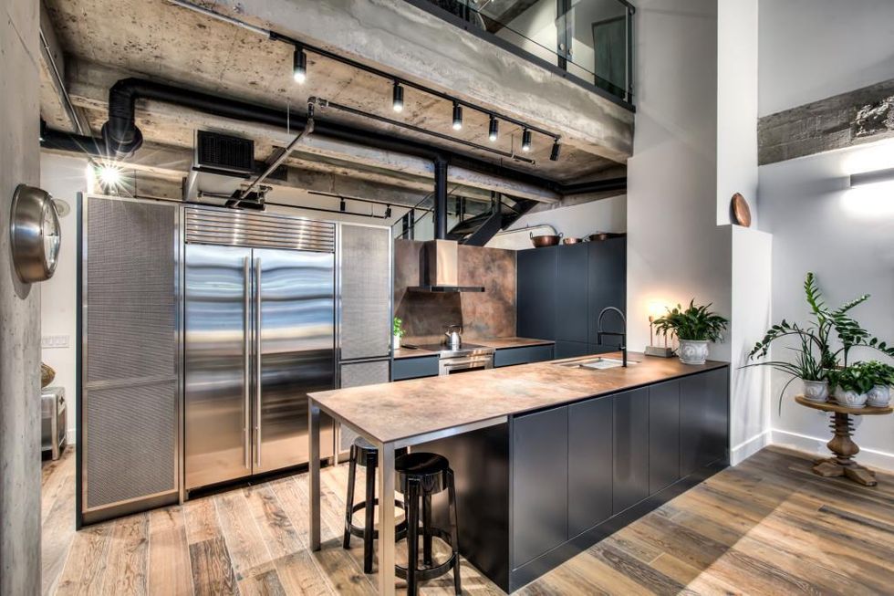 La cuisine avec \u00eelot et \u00e9lectrom\u00e9nagers en stainless steel.