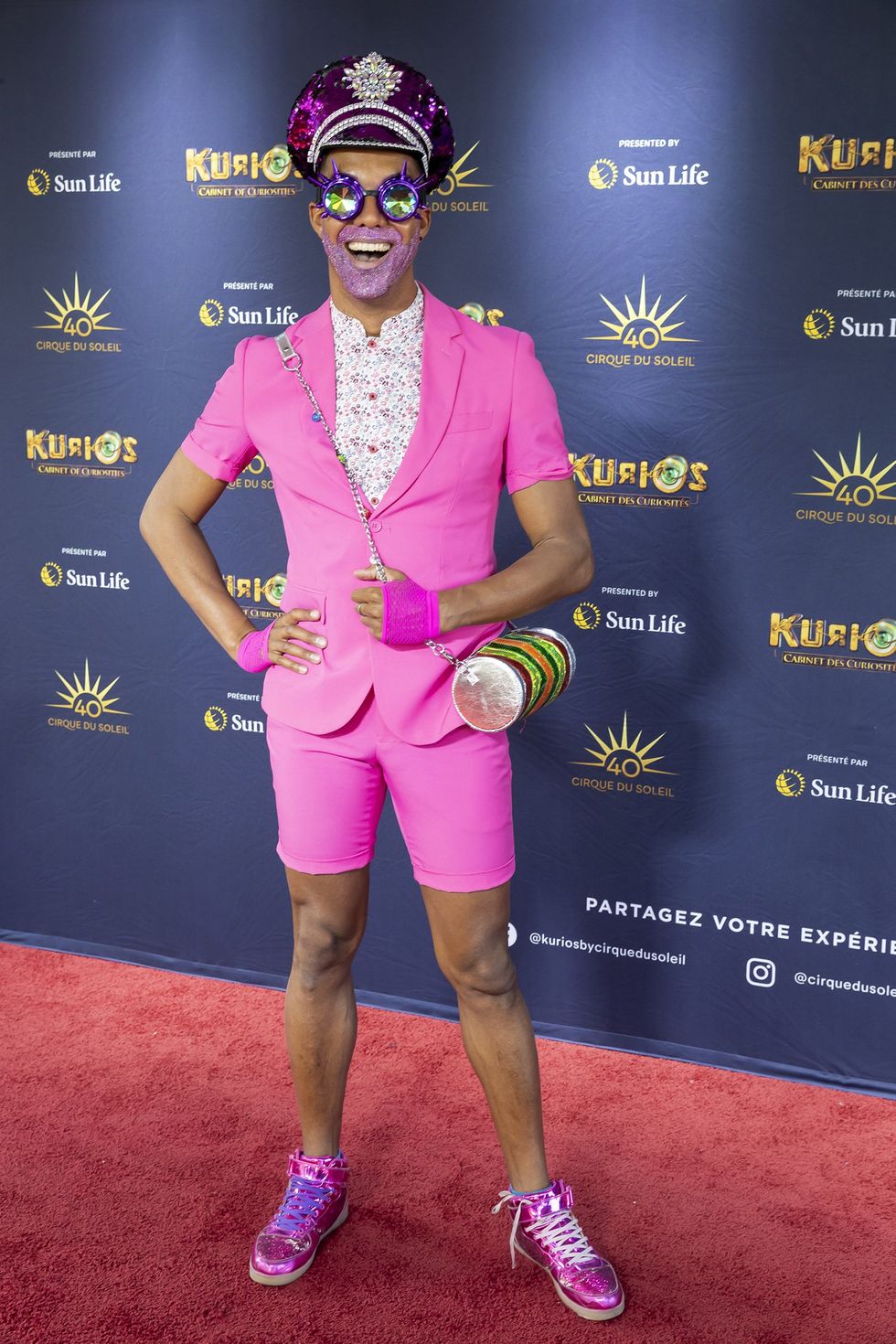 La drag queen Barbada de Barbades, tout en rose avec une barbe \u00e0 paillettes, sur le tapis rouge de Kurios du Cirque du Soleil.